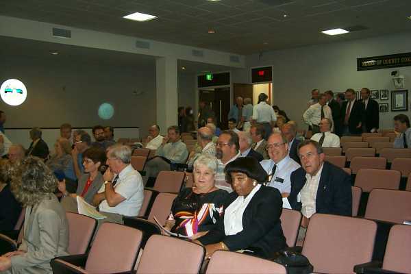 photo: group of people sitting in audotorium with another group standing in the back